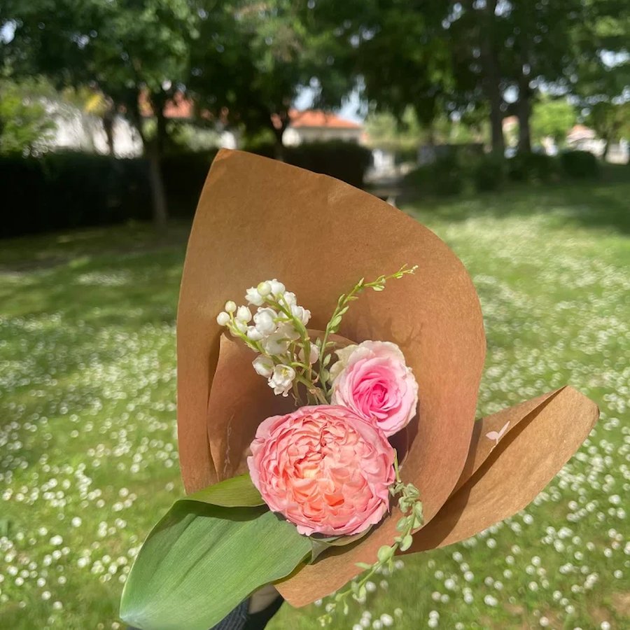 Bouquet de roses et muguet dans un emballage kraft